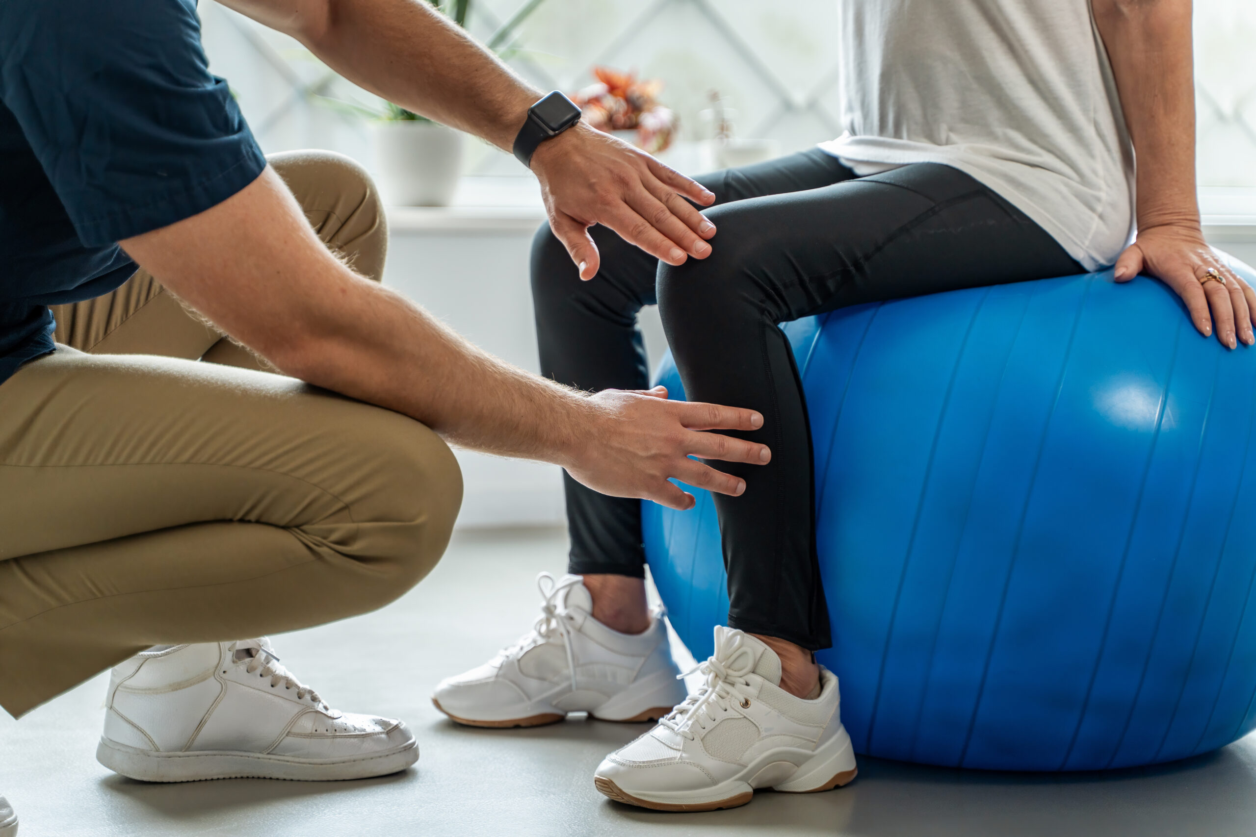 physical therapist helping his patient do an ankle-strengthening exercise