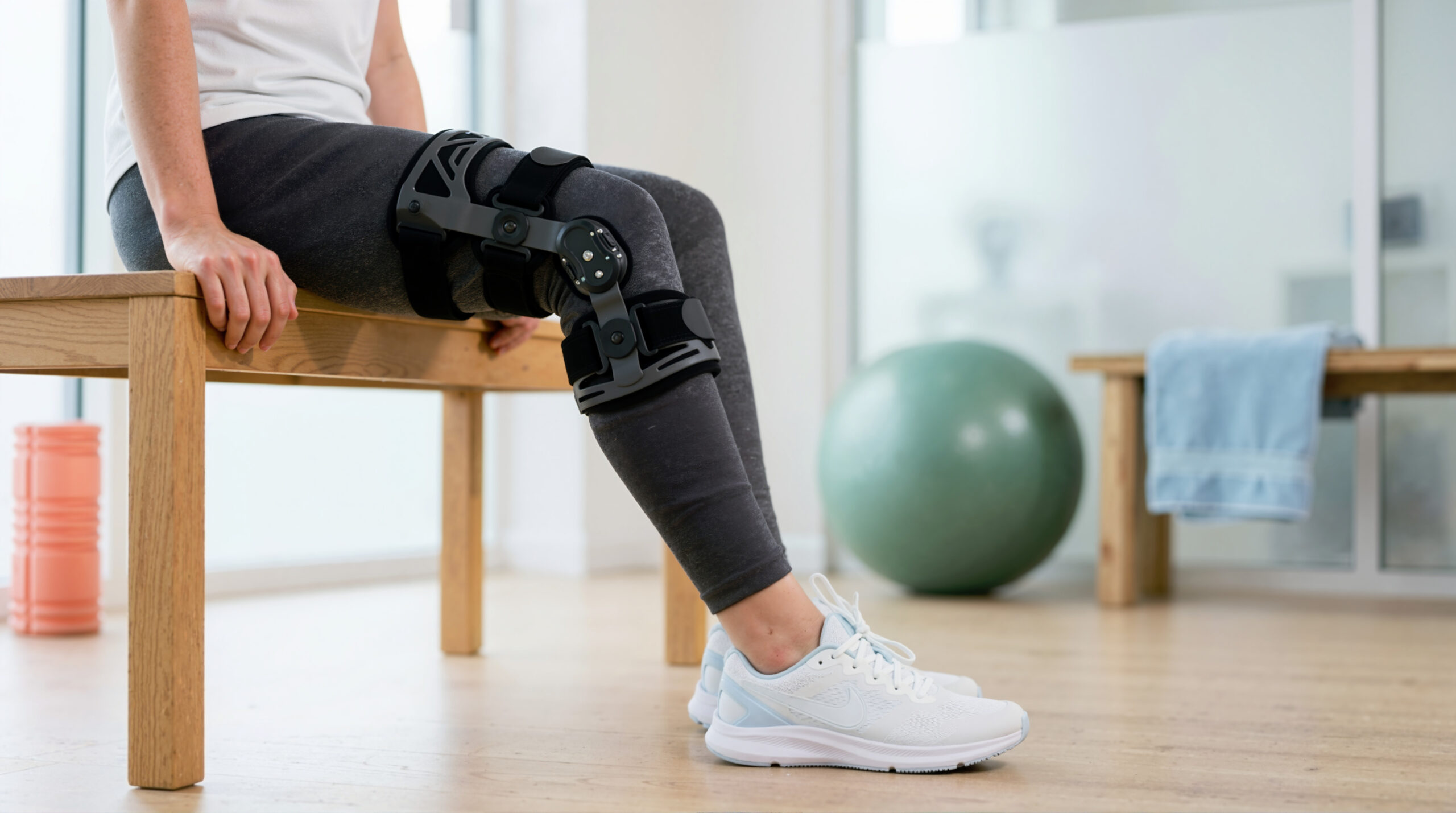 woman with a knee brace ready for her postoperative physical therapy session