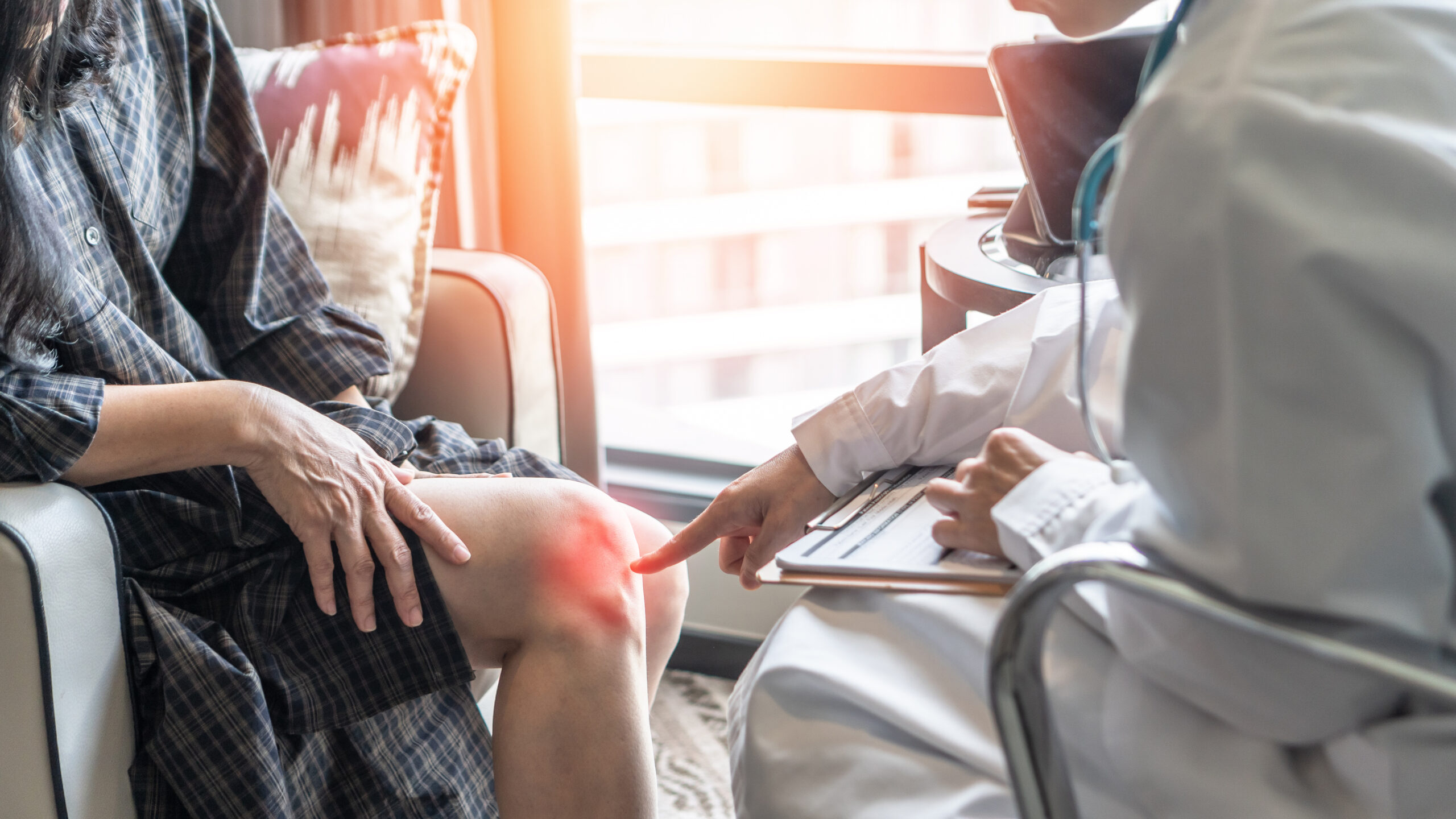 doctor examining his patient's knee to determine the best pre- and postoperative care